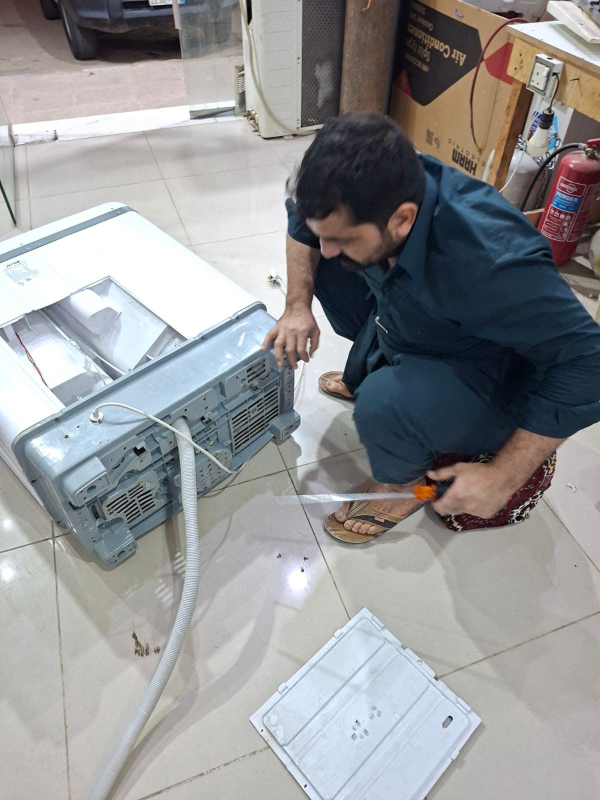 Technician fixing washing machine